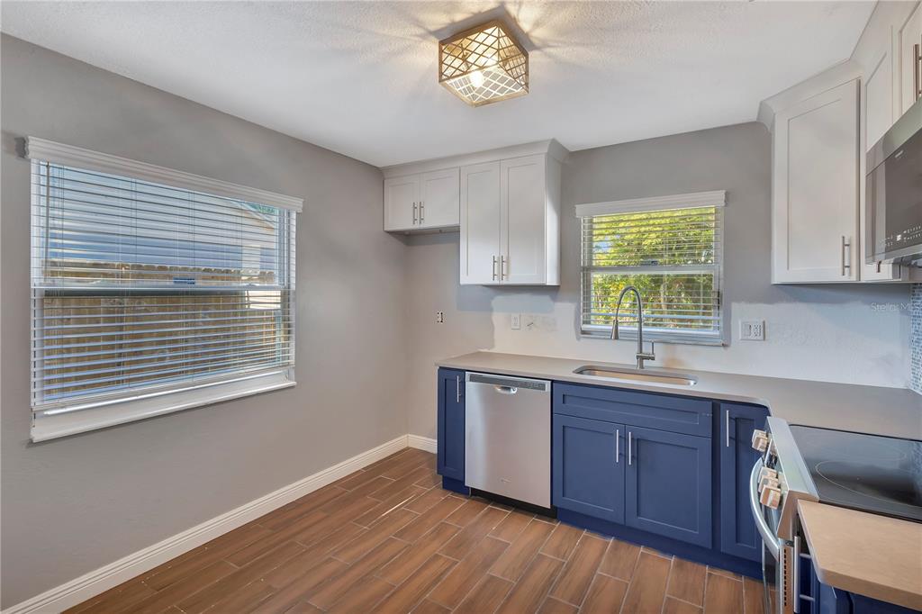 7737 Mitchell Ranch Road New Port Richey, FL 34655 - Photo 8 of 27 a kitchen with stainless steel appliances granite countertop a sink a stove a window cabinets and wooden floor