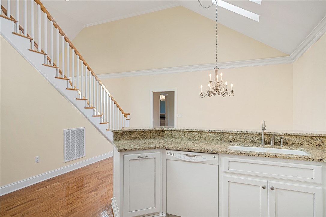 16 Oleander Drive Anderson, SC 29621 - Photo 15 of 37 A striking vaulted ceiling highlights the open living area, featuring a modern kitchen counter and staircase.