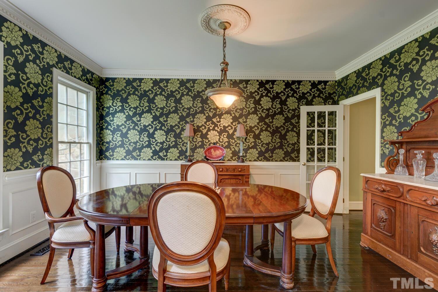 2021 Rolling Rock Road Wake Forest, NC 27587 - Photo 6 of 27 a dining room with furniture a potted plant and wooden floor
