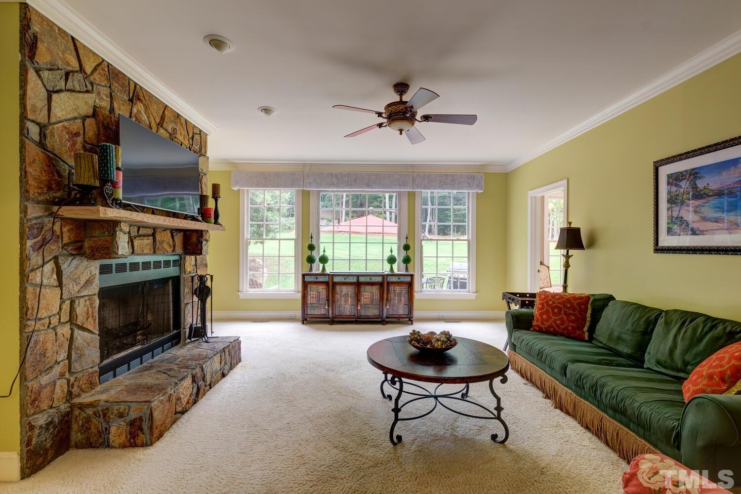 2021 Rolling Rock Road Wake Forest, NC 27587 - Photo 8 of 27 a living room with furniture a flat screen tv and a fireplace