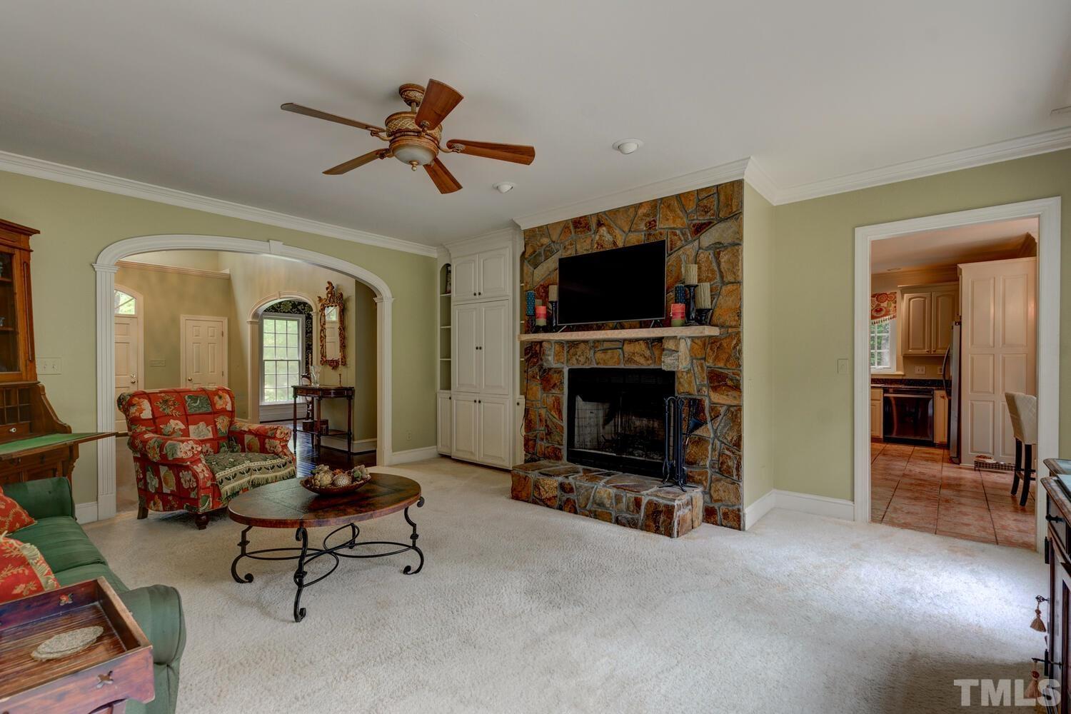 2021 Rolling Rock Road Wake Forest, NC 27587 - Photo 9 of 27 a living room with furniture a flat screen tv and a fireplace