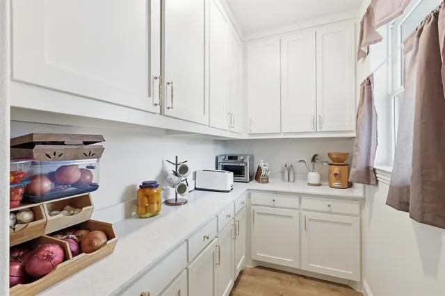 a bedroom with a bed a mirror and a large window
