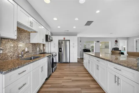 a large kitchen with granite countertop lots of counter space and sink