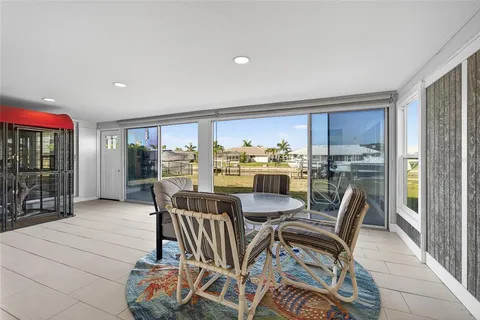 a dining room with furniture and a floor to ceiling window