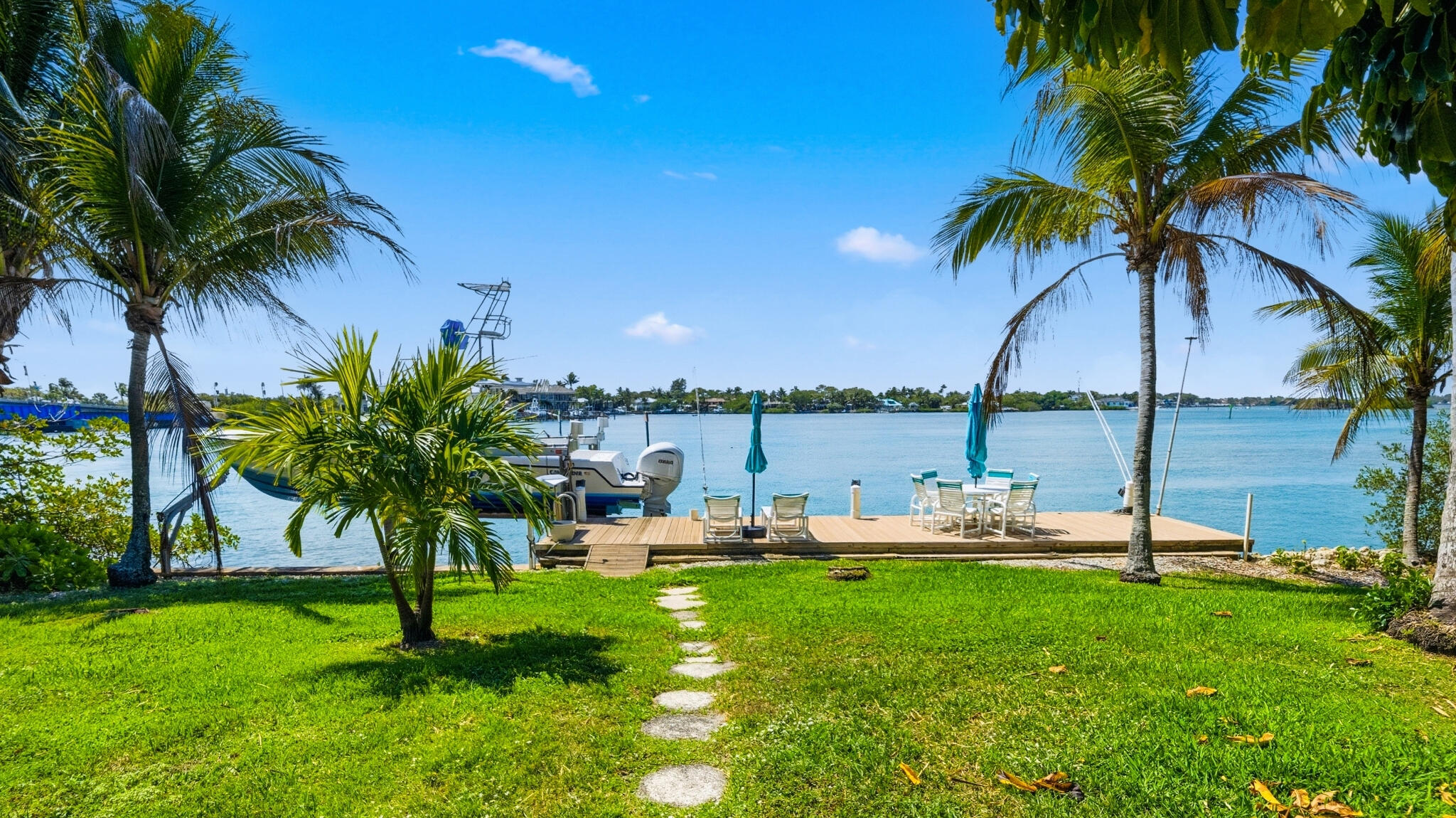 1305 Peninsular Road Jupiter, FL 33469 - Photo 2 of 23 a view of a backyard with lawn chairs under a palm tree