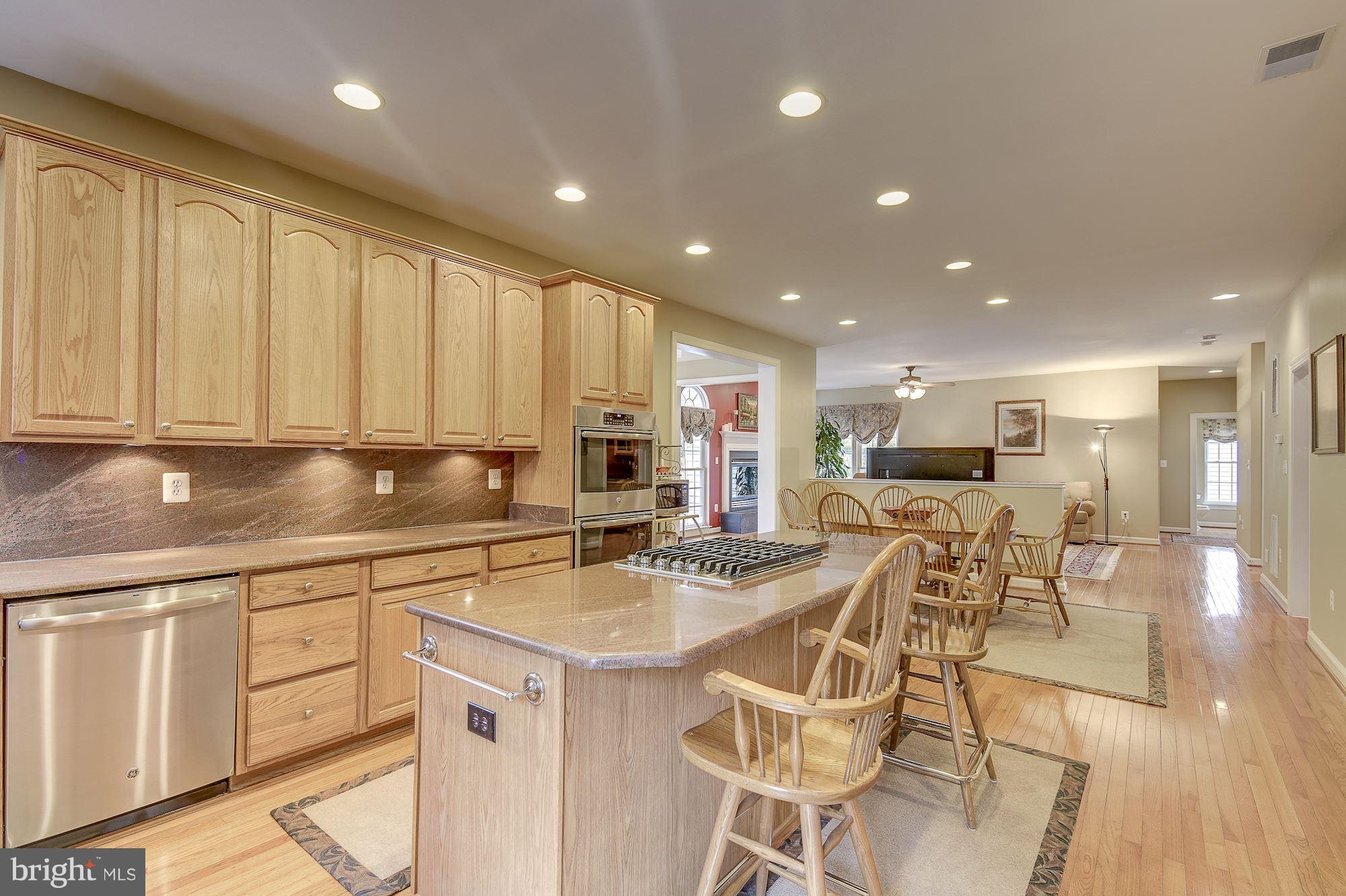 8639 Hillside Manor Drive Springfield, VA 22152 - Photo 2 of 30 a kitchen with stainless steel appliances granite countertop a table chairs sink and cabinets