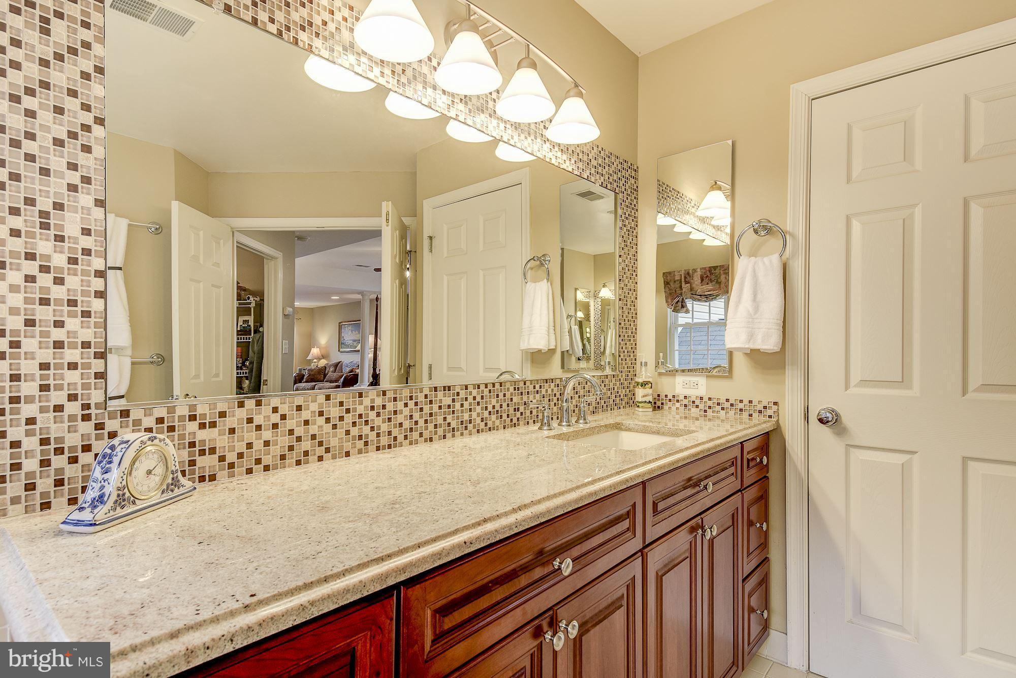 8639 Hillside Manor Drive Springfield, VA 22152 - Photo 19 of 30 a bathroom with a granite countertop sink and a mirror