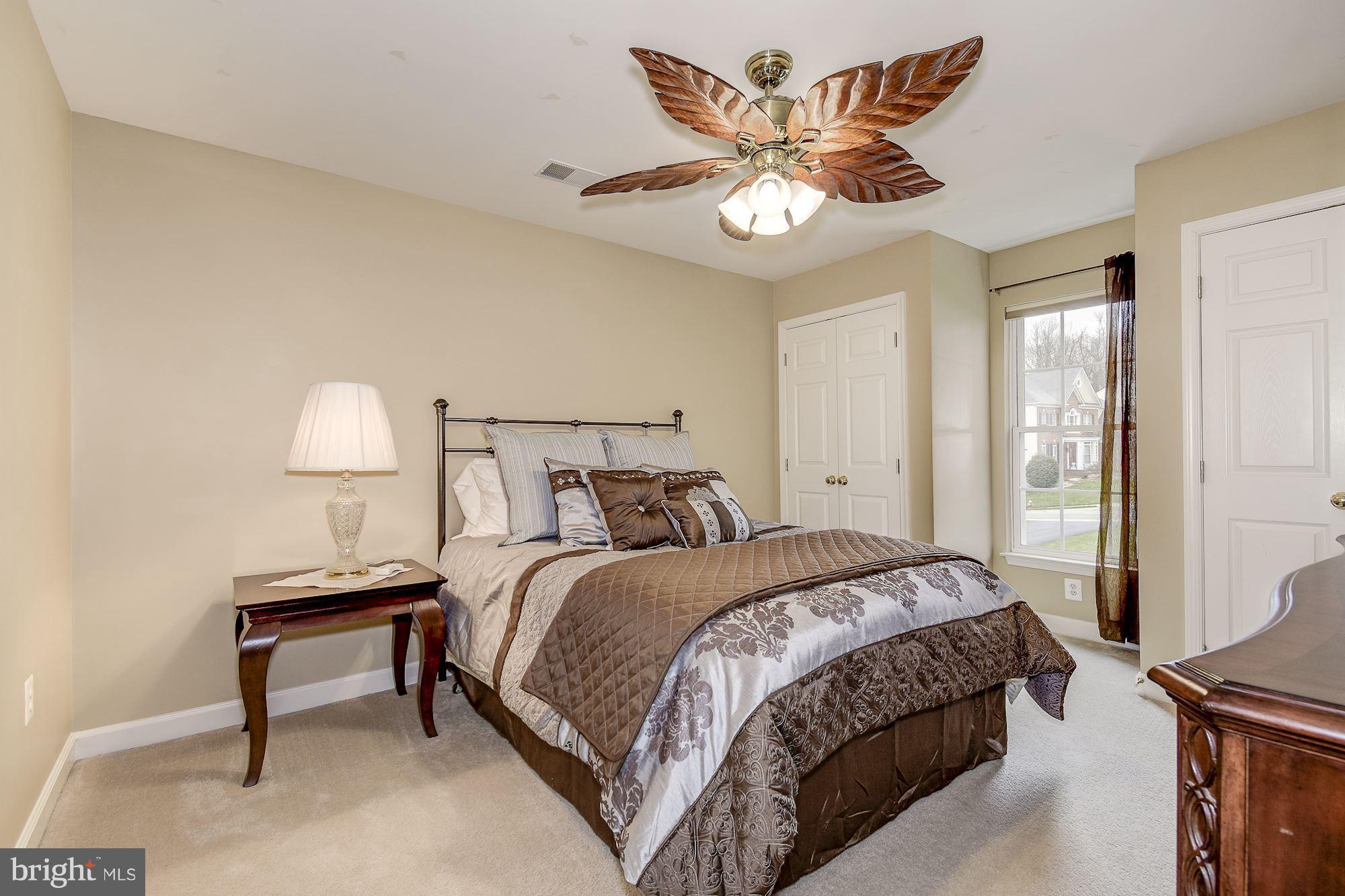 8639 Hillside Manor Drive Springfield, VA 22152 - Photo 21 of 30 a bedroom with a bed and a lamp on table