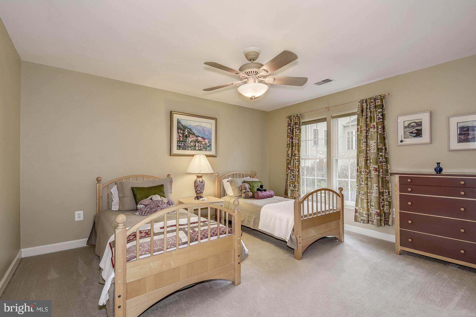 8639 Hillside Manor Drive Springfield, VA 22152 - Photo 22 of 30 a spacious bedroom with a bed and a chandelier