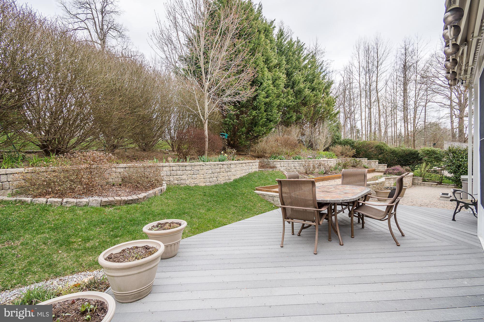 8639 Hillside Manor Drive Springfield, VA 22152 - Photo 25 of 30 a view of a backyard with table and chairs potted plants and tree