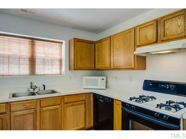 4512 Nightfall Court Durham, NC 27713 - Photo 11 of 24 a kitchen with stainless steel appliances granite countertop a stove a sink dishwasher and cabinets with wooden floor