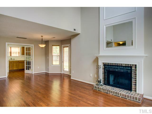 4512 Nightfall Court Durham, NC 27713 - Photo 4 of 24 a view of an empty room with wooden floor and a fireplace