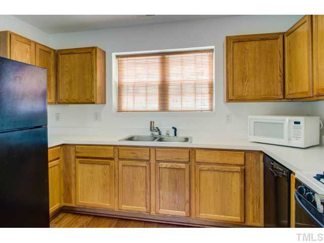 4512 Nightfall Court Durham, NC 27713 - Photo 10 of 24 a kitchen with white cabinets and a sink