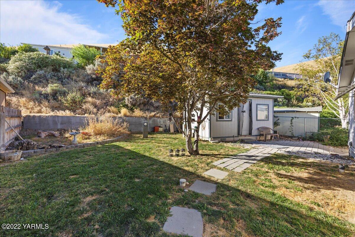 300 Alps Road, Unit 1008 Moxee, WA 98936 - Photo 18 of 22 a view of a yard with plants and a tree