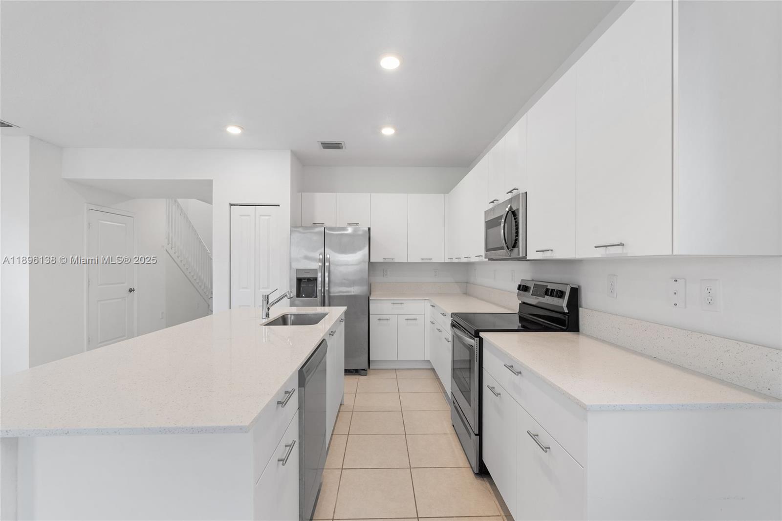 2405 Northwest 131st Street Miami, FL 33167 - Photo 14 of 38 a kitchen with a sink a stove top oven and white stainless steel appliances