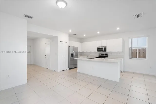 a kitchen with white cabinets a sink and white appliances