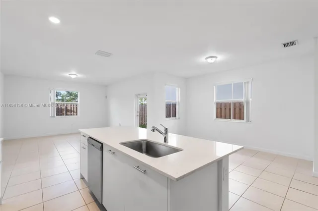 a kitchen with a sink a counter top space and cabinets