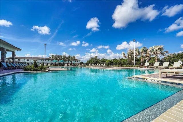 a kitchen with a dining table chairs sink and white cabinets