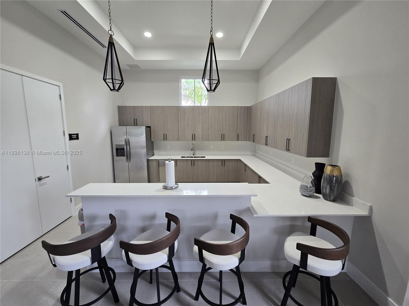 2405 Northwest 131st Street Miami, FL 33167 - Photo 38 of 38 a kitchen with a dining table chairs sink and white cabinets