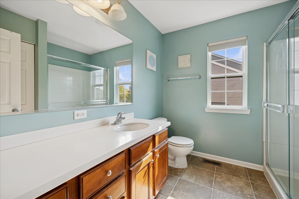 2681 Braeburn Way Woodstock, IL 60098 - Photo 21 of 41 a bathroom with a sink a toilet and a mirror
