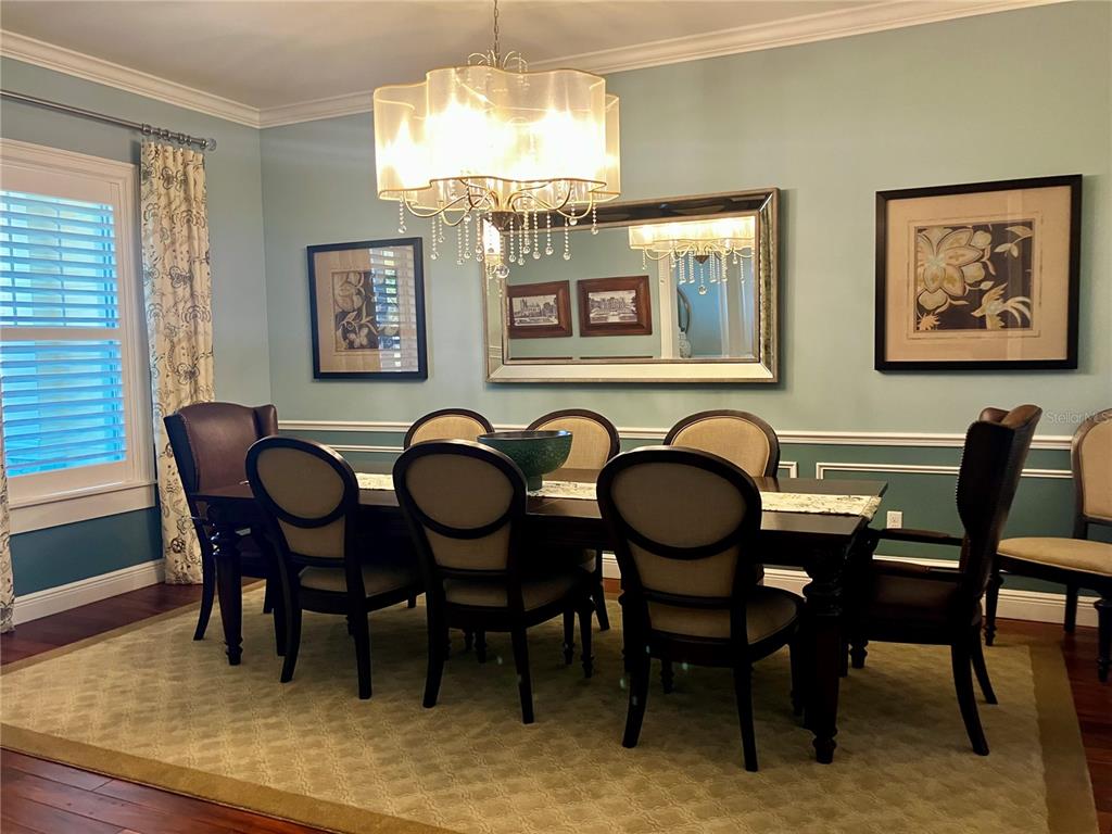 3709 Gallagher Road Plant City, FL 33565 - Photo 13 of 60 a view of a dining room with furniture a chandelier and wooden floor