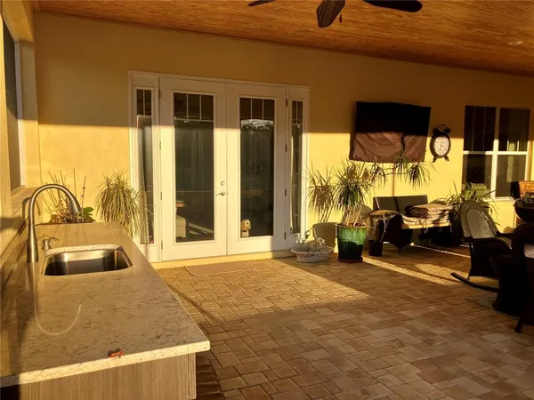 a view of a house with potted plants and a bench