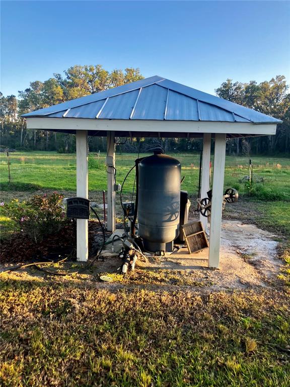 3709 Gallagher Road Plant City, FL 33565 - Photo 39 of 60 a view of a backyard with table and chairs under an umbrella with wooden floor