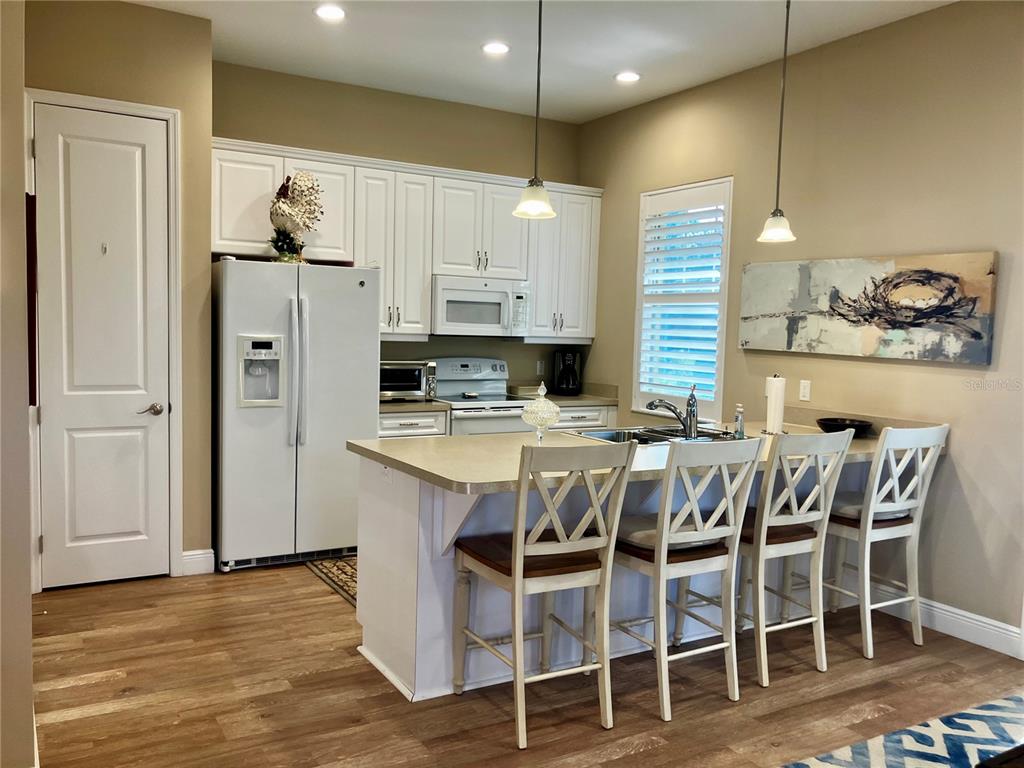 3709 Gallagher Road Plant City, FL 33565 - Photo 48 of 60 a kitchen with stainless steel appliances kitchen island granite countertop a table chairs and a refrigerator