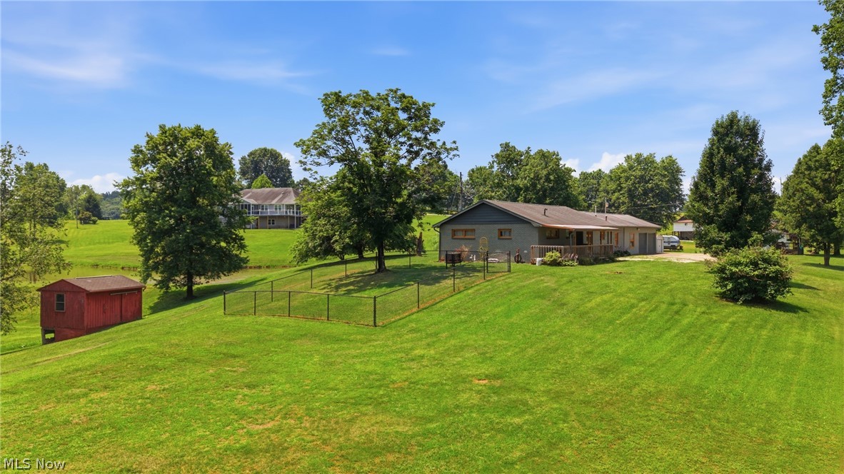 89 Dagg Road Parkersburg, WV 26101 - Photo 3 of 45 Expansive green lawn with mature trees and a fenced area