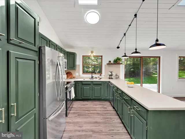 a kitchen with stainless steel appliances granite countertop a refrigerator and a sink
