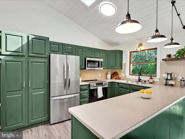 a kitchen with sink a refrigerator and chairs
