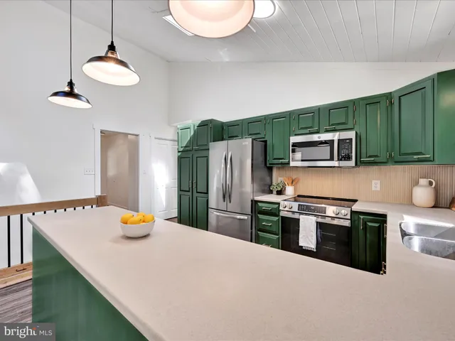 a kitchen with stainless steel appliances granite countertop a sink refrigerator and microwave