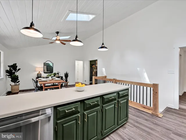 a kitchen with a sink a chandelier and living room view