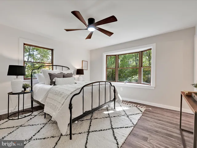 a bedroom with a bed next to a window with a chandelier