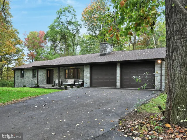 a front view of a house with a garden and trees