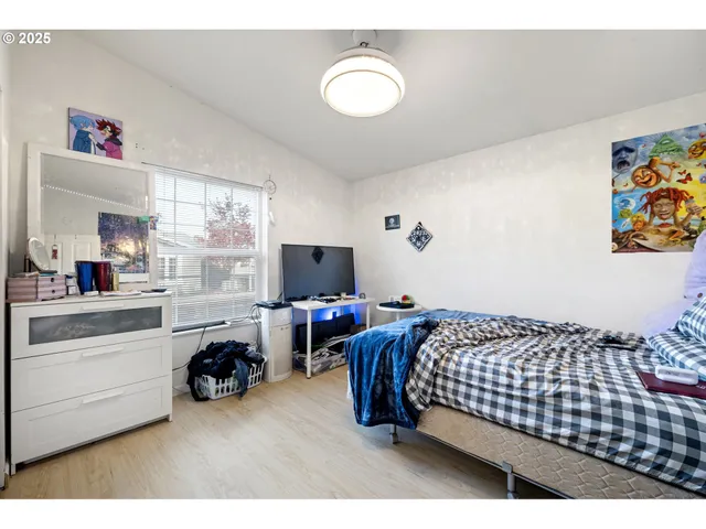 a bedroom with bed and a flat screen tv
