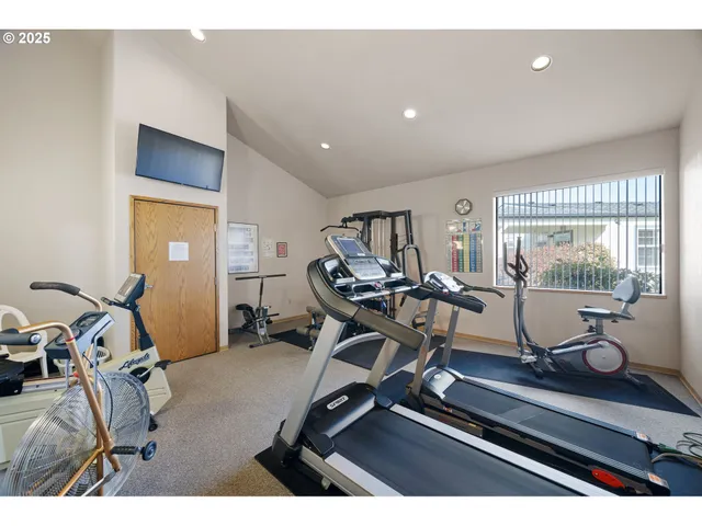 a room with gym equipment and large windows
