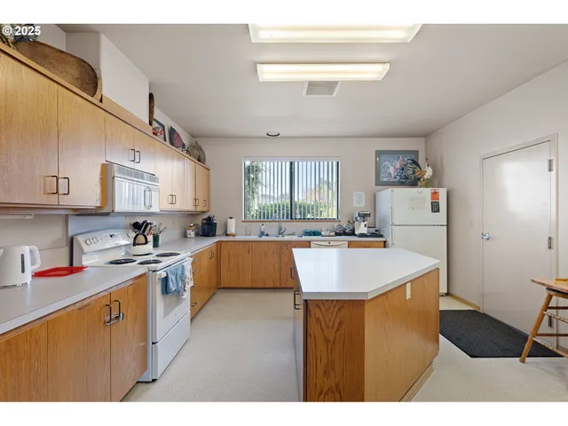 a kitchen with stainless steel appliances kitchen island wooden cabinets a stove a sink and a refrigerator