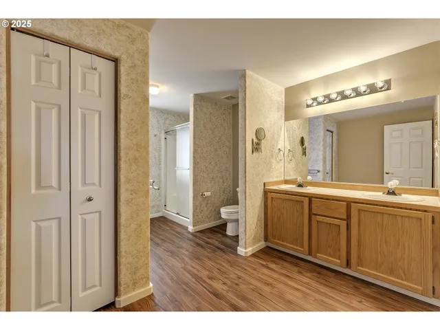 a bathroom with a sink a toilet and a large mirror