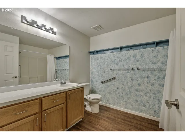 a bathroom with a sink a toilet and shower