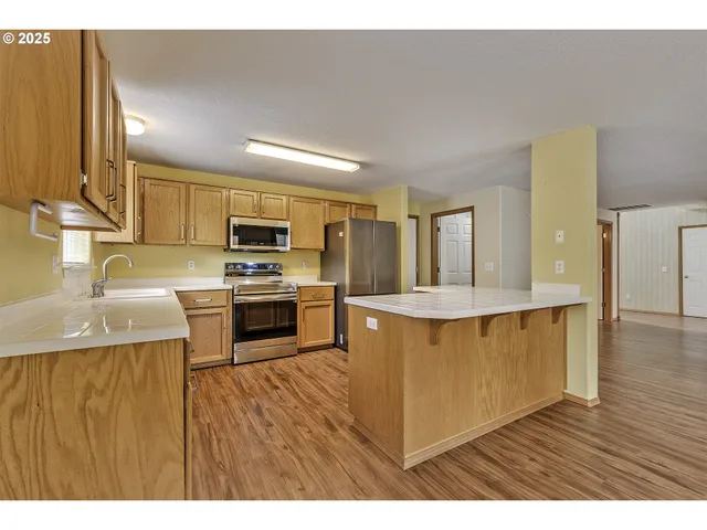 a kitchen with stainless steel appliances granite countertop a stove a sink and a refrigerator