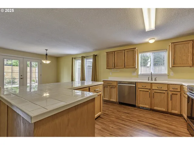 a kitchen with granite countertop a sink cabinets and wooden floor