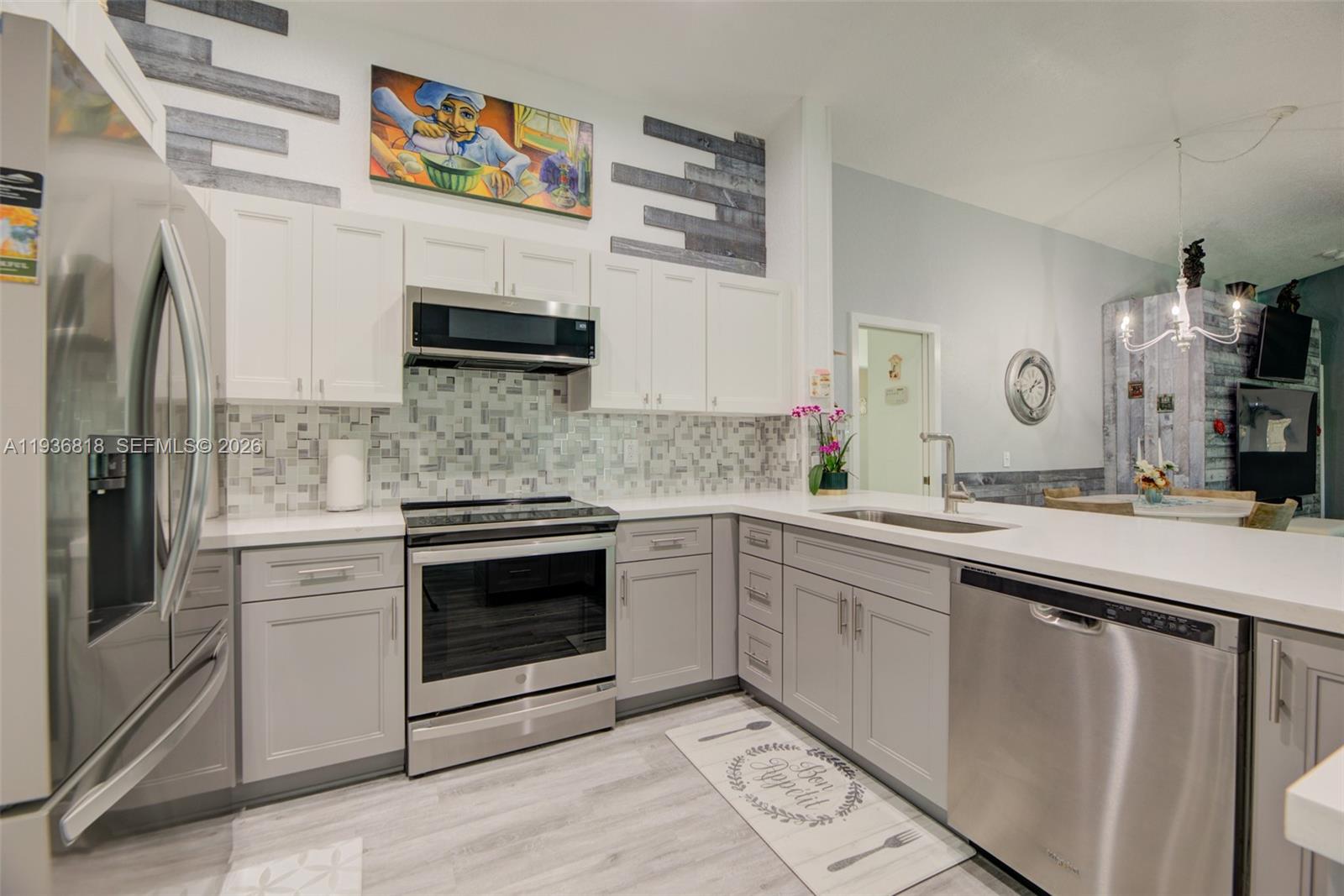 1409 Majesty Terrace Weston, FL 33327 - Photo 24 of 61 a kitchen with cabinets stainless steel appliances and a sink