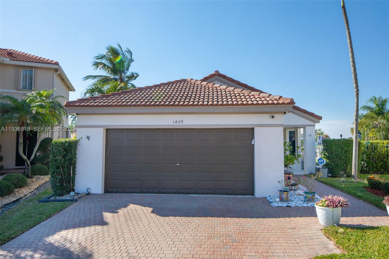 1409 Majesty Terrace Weston, FL 33327 - Photo 5 of 61 a front view of a house with a garden