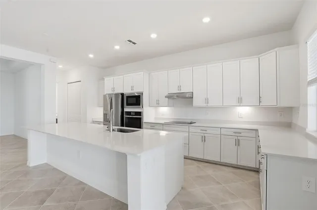 a kitchen with stainless steel appliances granite countertop a refrigerator sink and cabinets