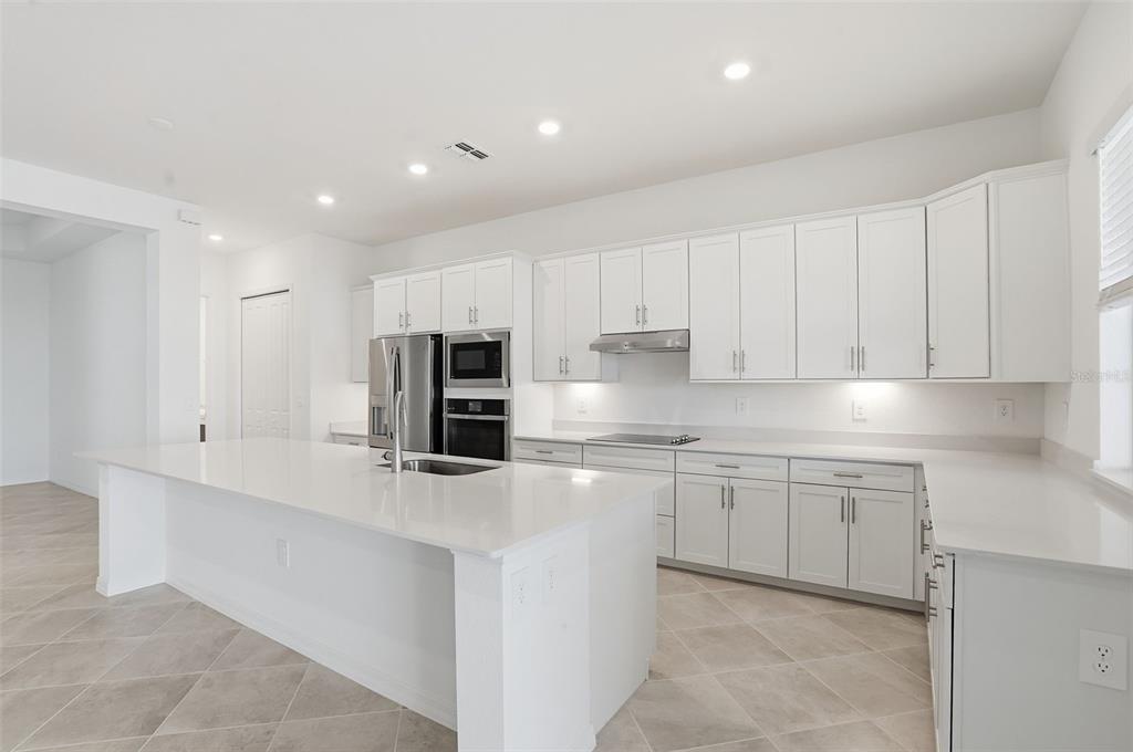 13092 Tulum Loop Venice, FL 34293 - Photo 13 of 24 a kitchen with stainless steel appliances granite countertop a refrigerator sink and cabinets