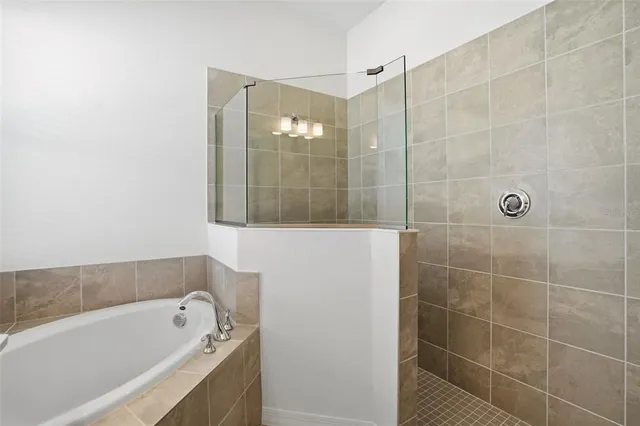 a bathroom with a sink double vanity granite tub shower and a mirror