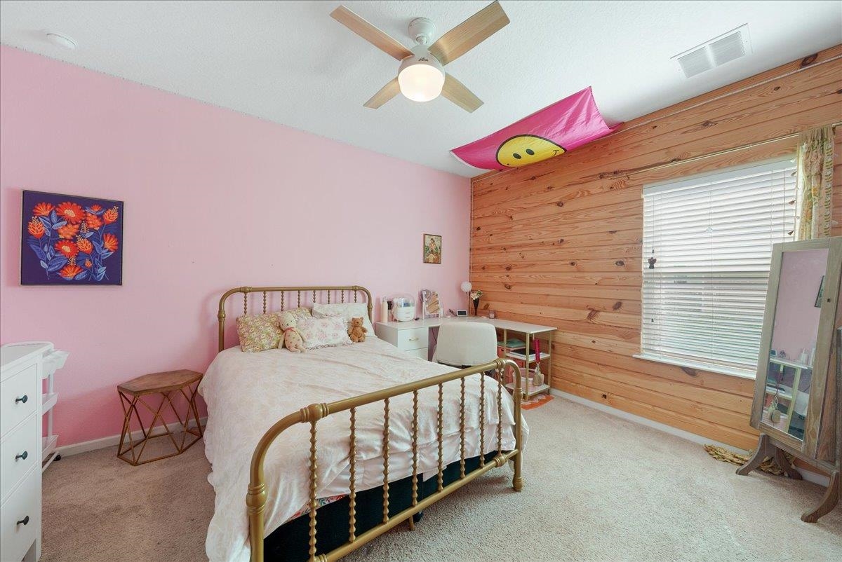 110 Ceja Way St. Augustine, FL 32095 - Photo 19 of 78 a bedroom with a bed and a chandelier