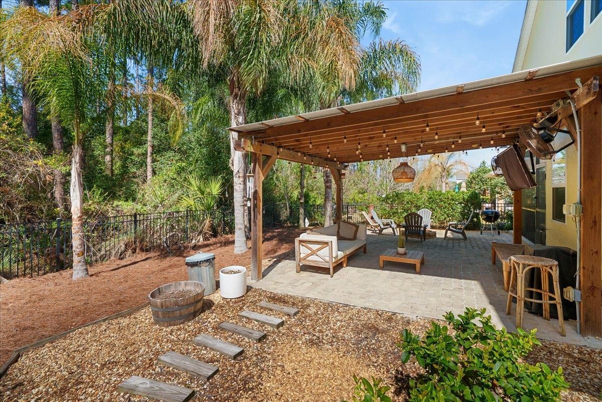 110 Ceja Way St. Augustine, FL 32095 - Photo 38 of 78 a view of a patio with table and chairs potted plants and large tree