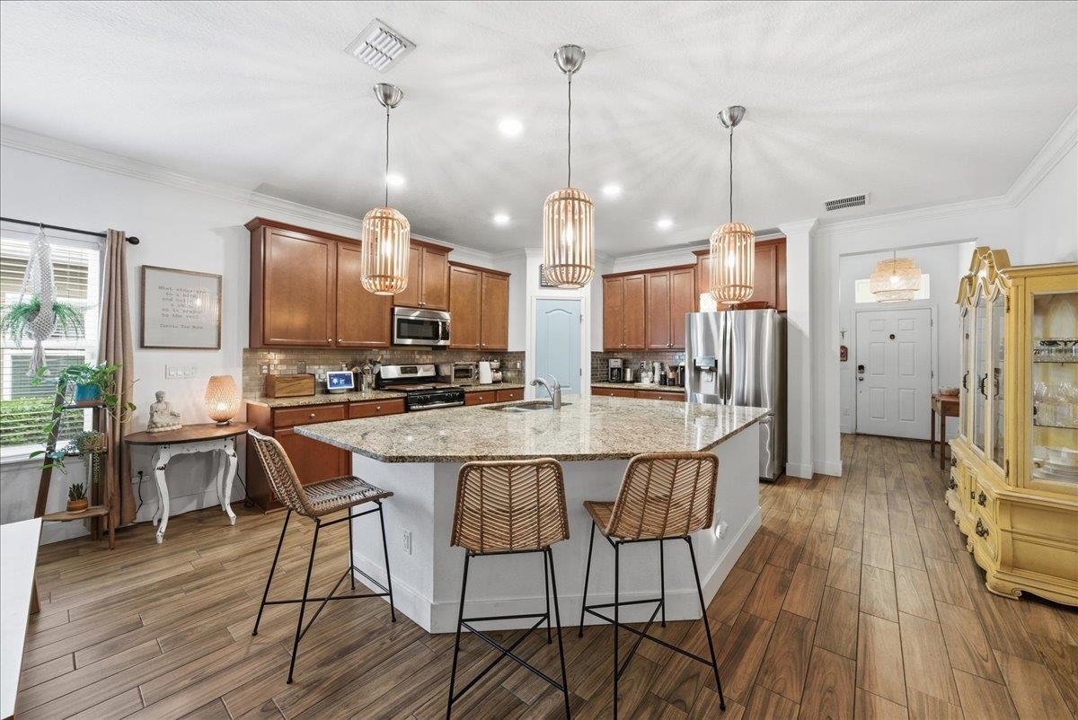 110 Ceja Way St. Augustine, FL 32095 - Photo 6 of 78 a kitchen with stainless steel appliances a dining table chairs a sink and white cabinets